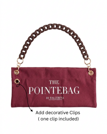"The PointeBag By Ballerina in burgundy with decorative clip attachment point — customizable ballet bag with dark chain strap and gold hardware"