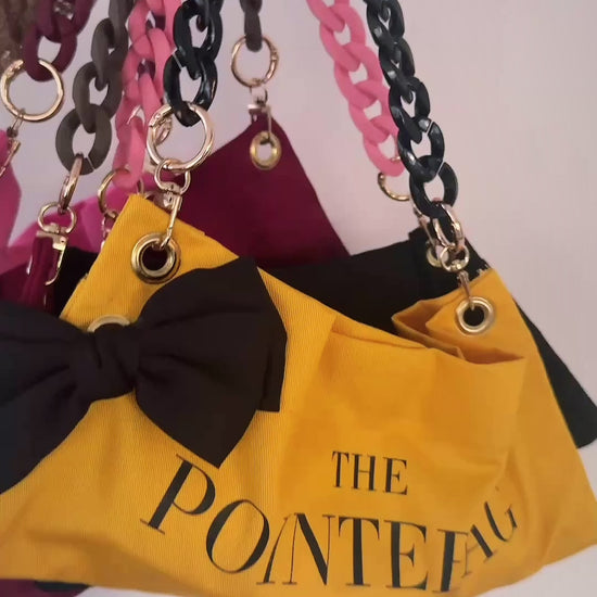 "PointeBag by Ballerina — close-up of premium cotton fabric, velvety touch, gold chains and swappable clips"